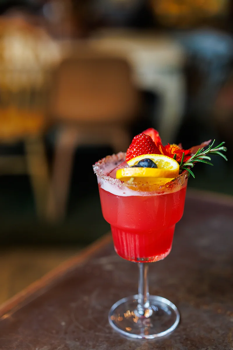 Colorful cocktail with fruit garnish at Wallflowers Cafe in Bangkok