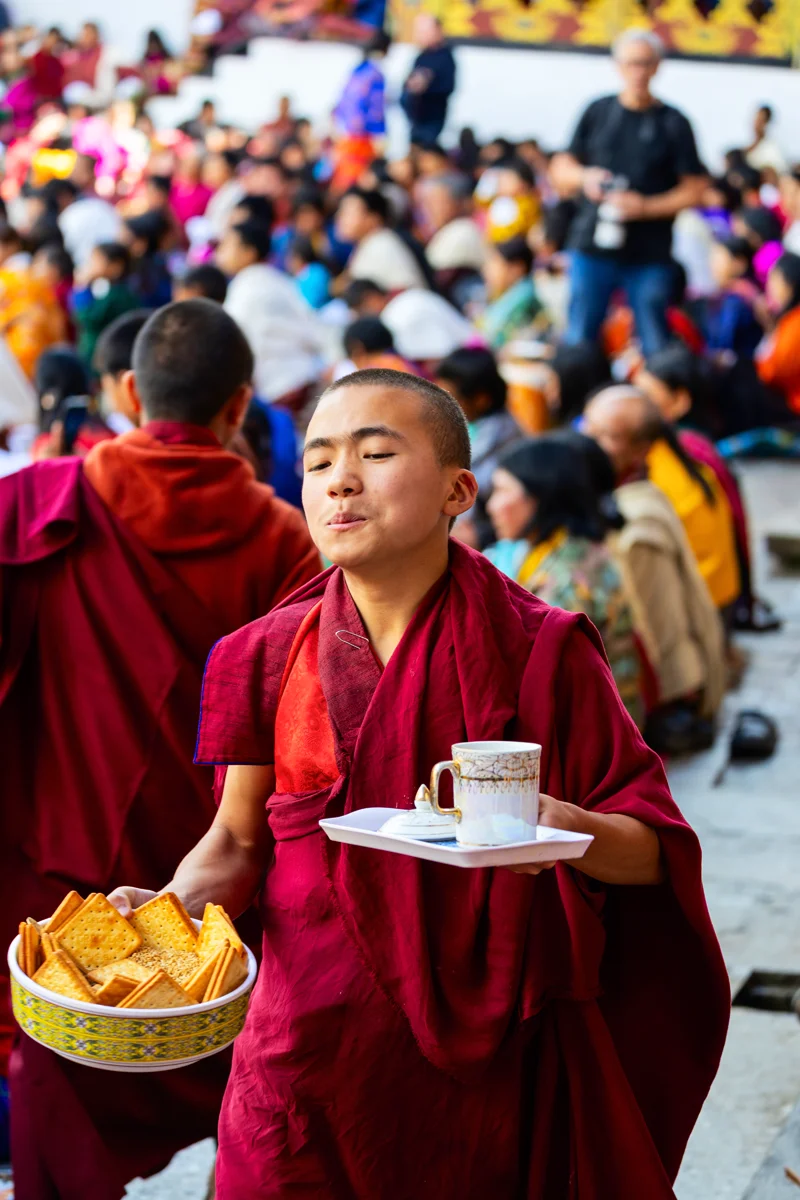 Young monk at Gangtey festival with snacks