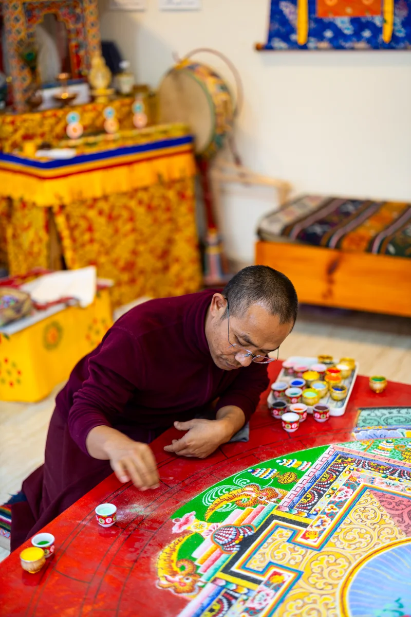 Monk creating intricate sand mandala art
