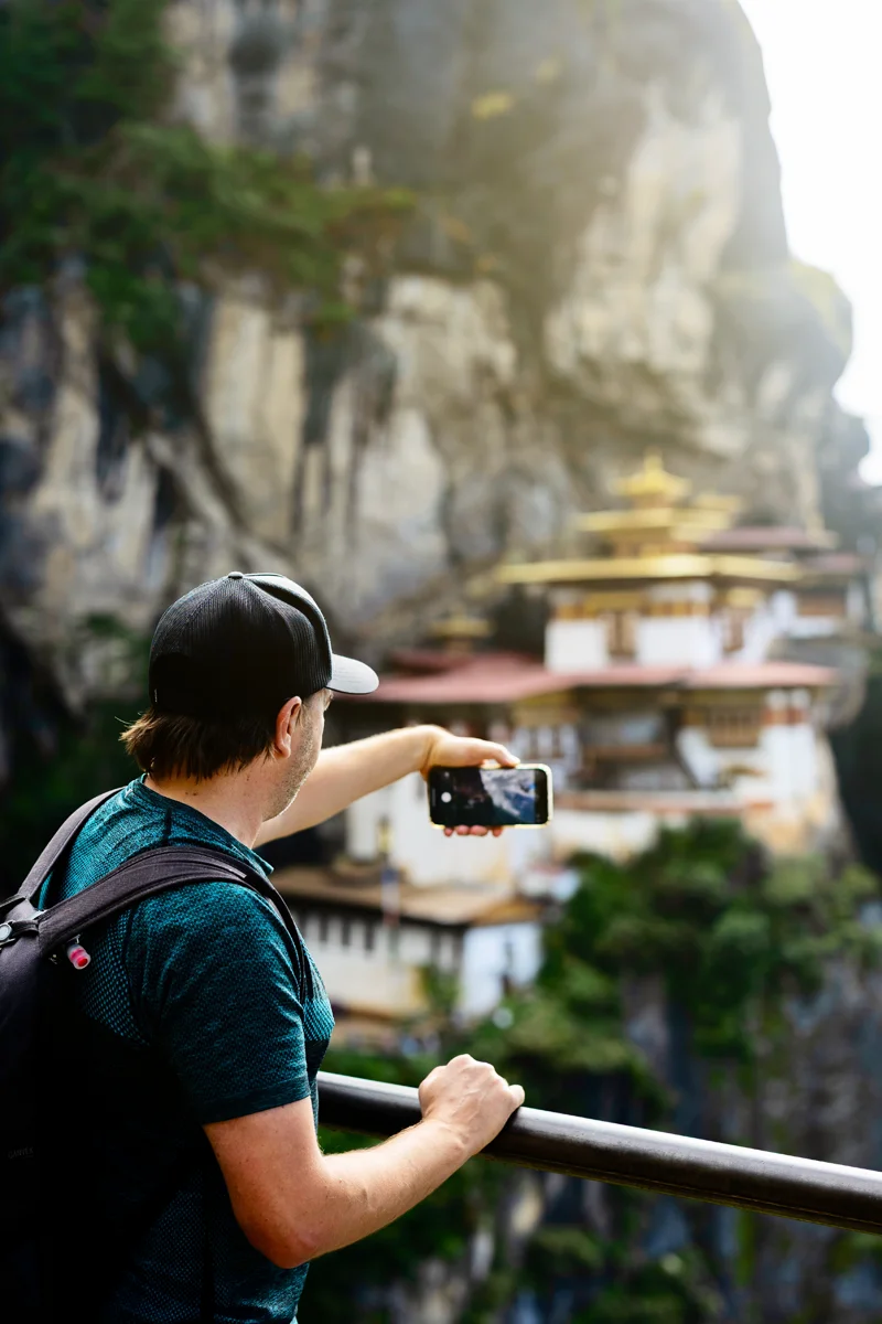 Person photographing iconic Tiger's Nest cliffside monastery