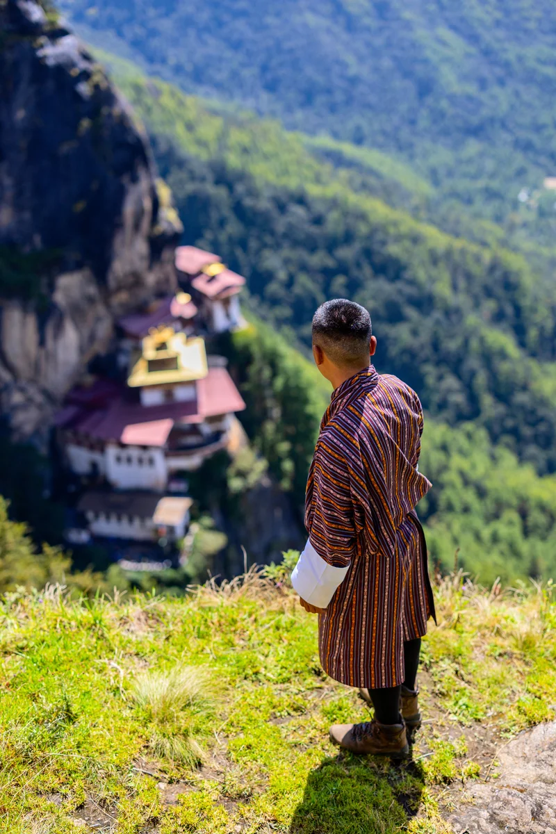 Bhutanese man overlooking cliffside Tiger's Nest monastery