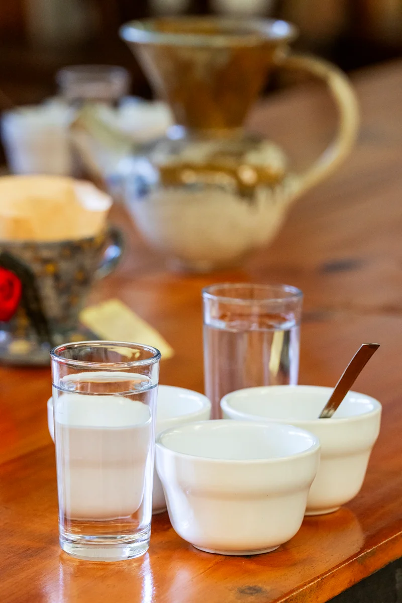 Glasses and bowls on wooden table prepared for coffee tasting or cupping