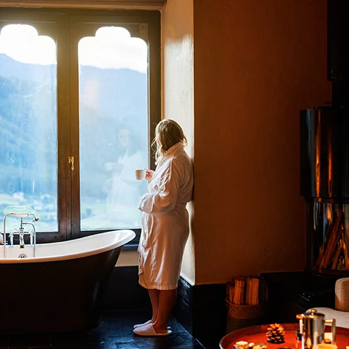 Person in bathrobe by window at Gangtey Lodge in Bhutan