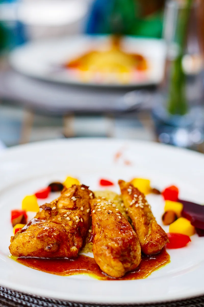 African-style chicken main course served with colorful accompaniments and native herbs at Giraffe Manor hotel in Kenya