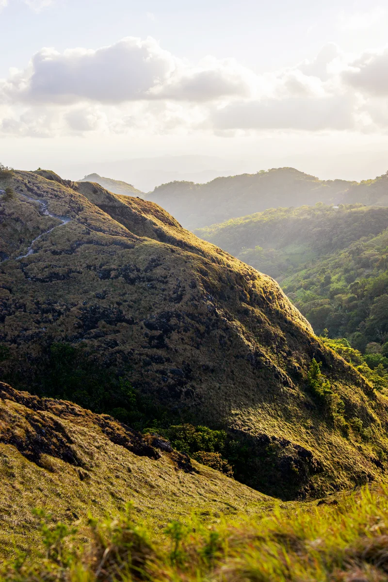 Lush green mountains under cloudy sky