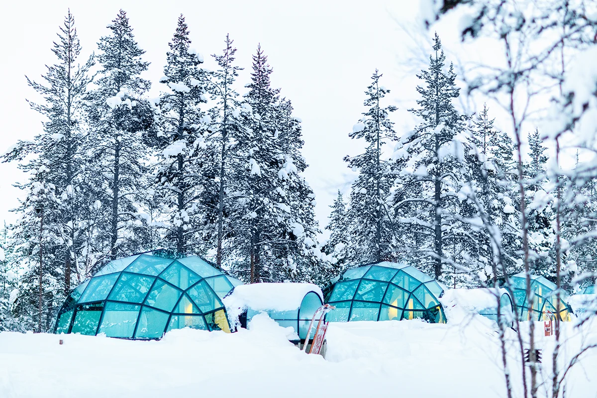 Glass igloos nestled in a snowy forest at Kakslauttanen Hotel in Finland