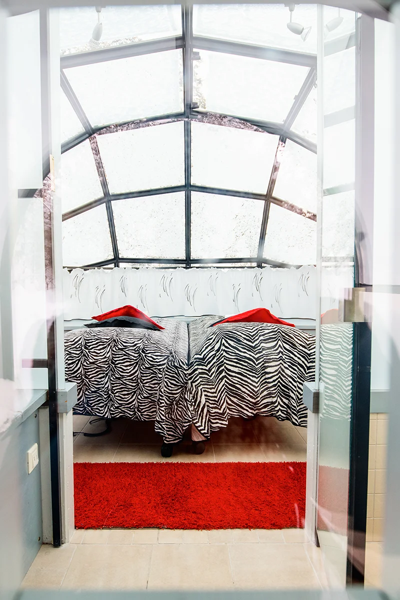 Interior of a glass igloo showing bed and furnishings at Kakslauttanen Arctic Resort in Finland