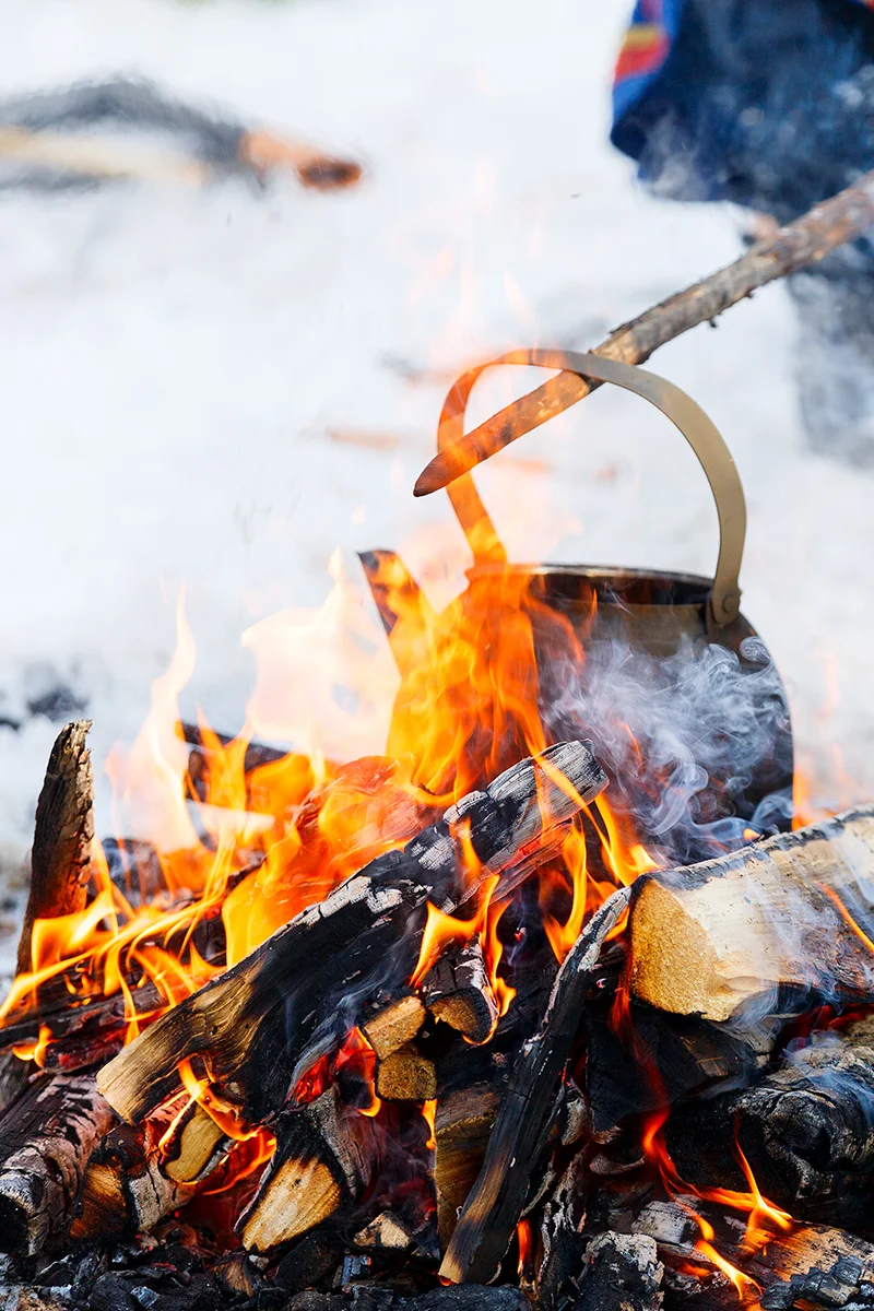 Campfire during a winter safari tour in a snow-covered forest in Finnish Lapland