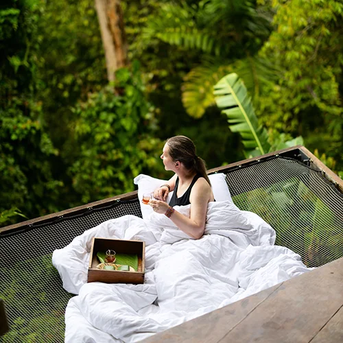 Person relaxing in jungle lodge