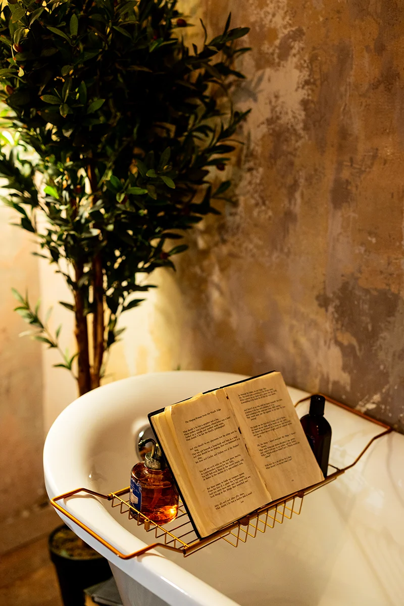 Book and toiletries on bathtub