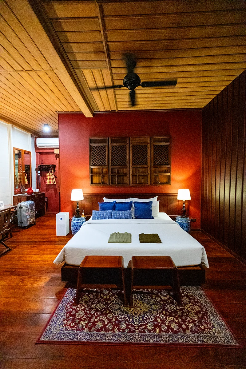 Cozy bedroom with wooden decor at Neil Niwas hotel in Bangkok
