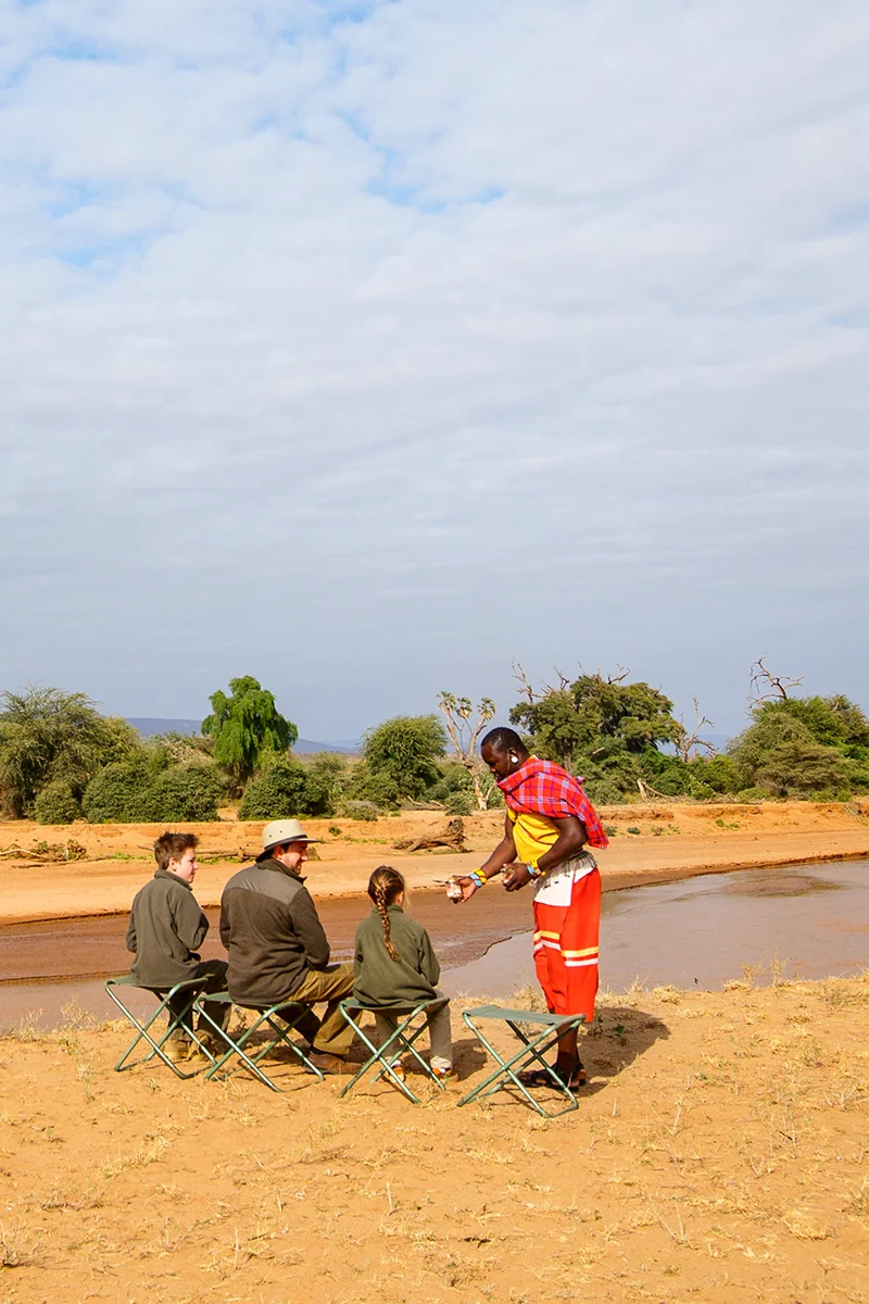 Family enjoying bush breakfast overlooking the Ewaso Ng'iro River in Samburu Kenya