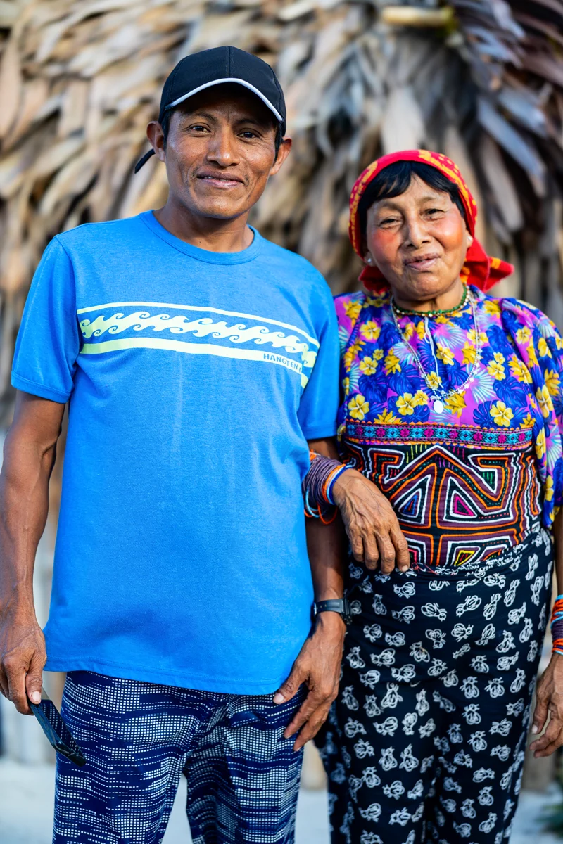 Two Guna people smiling in traditional clothing.