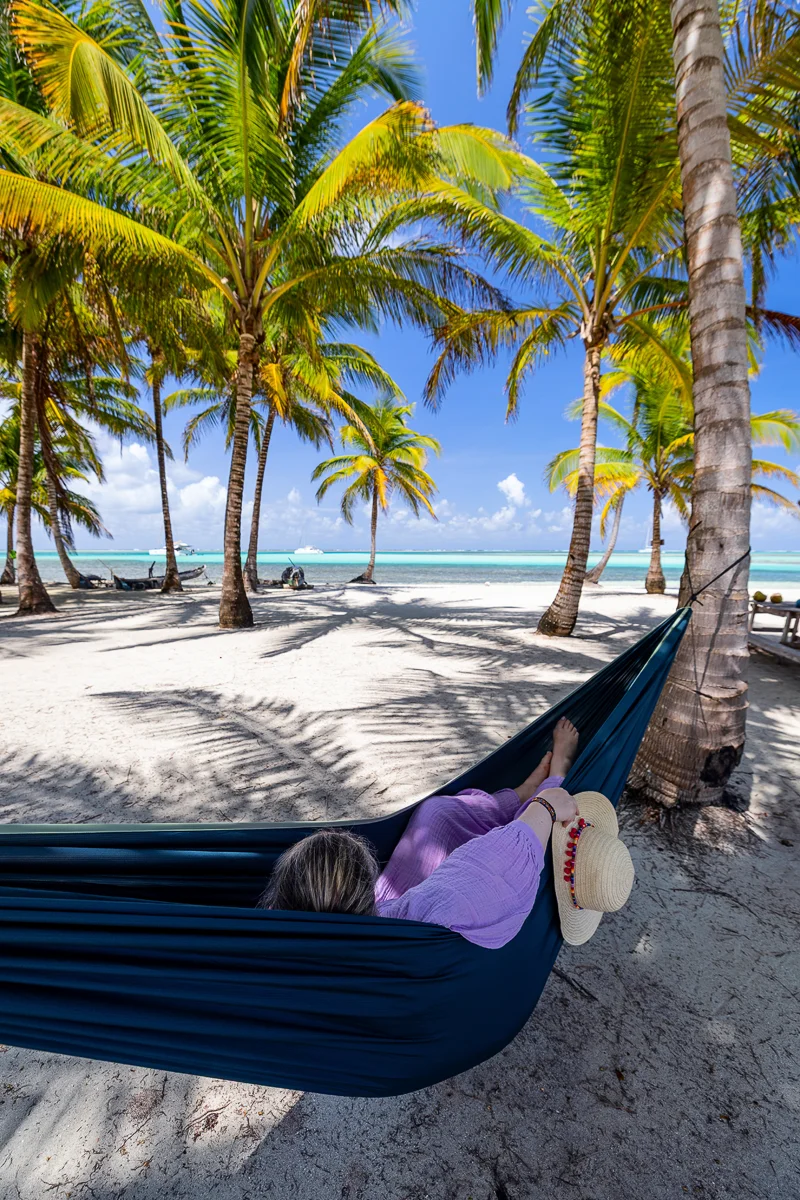 Woman relaxing in hammock under palms