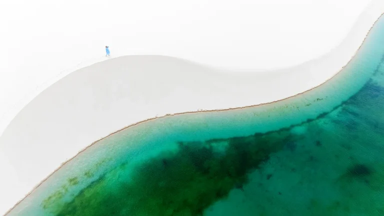 Aerial view of white sand dune and turquoise lagoon in Lençóis Maranhenses