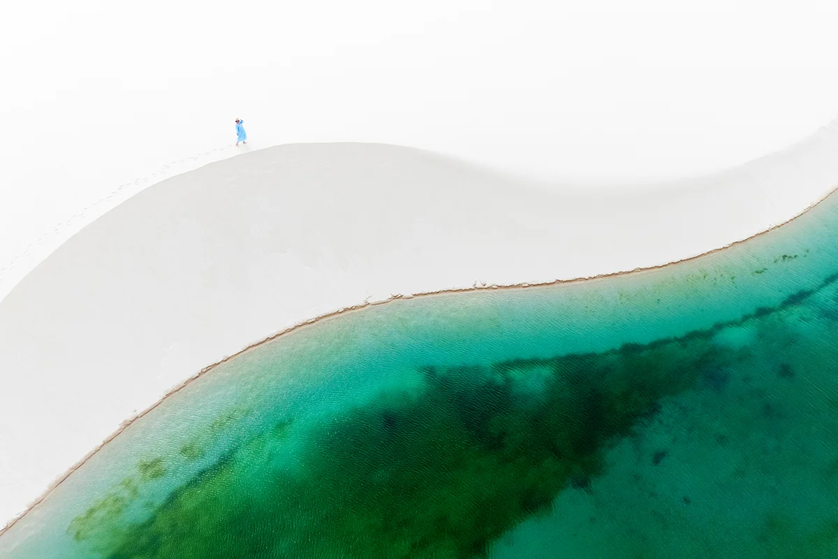 Aerial view of white sand dune and turquoise lagoon in Lençóis Maranhenses