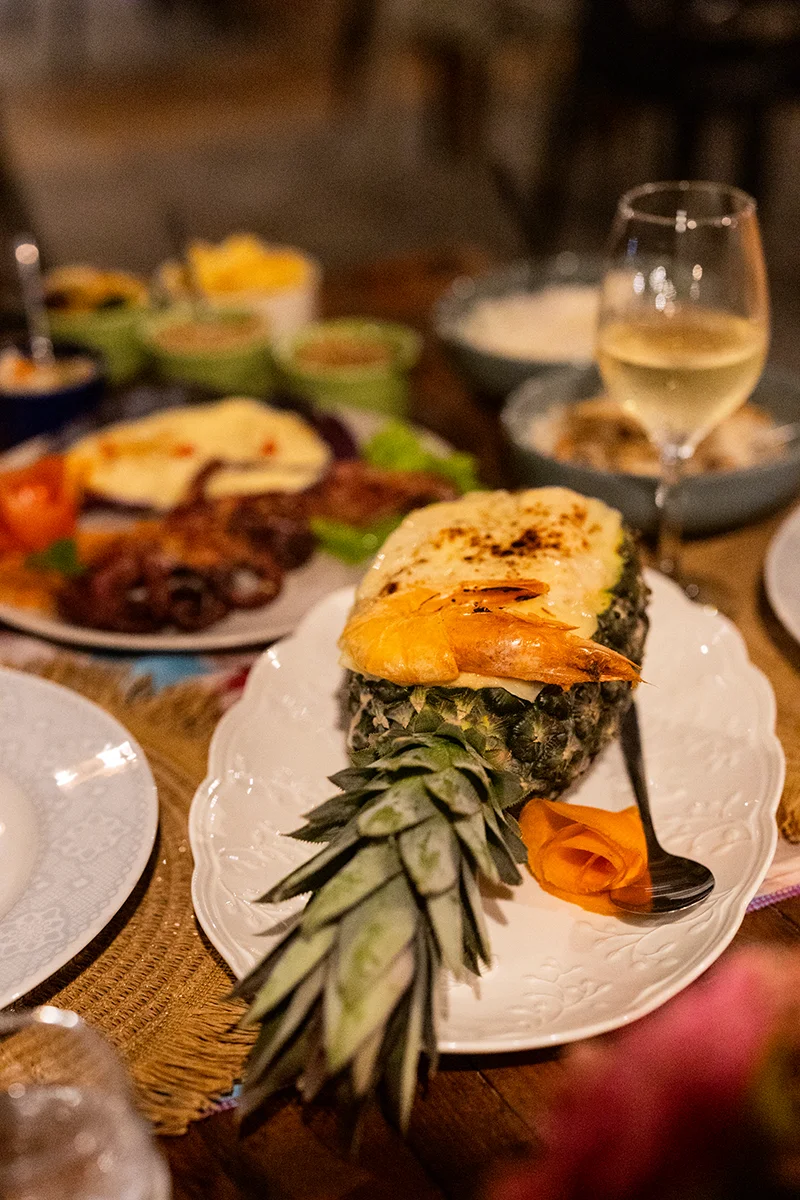 Shrimps in pineapple dish served with wine