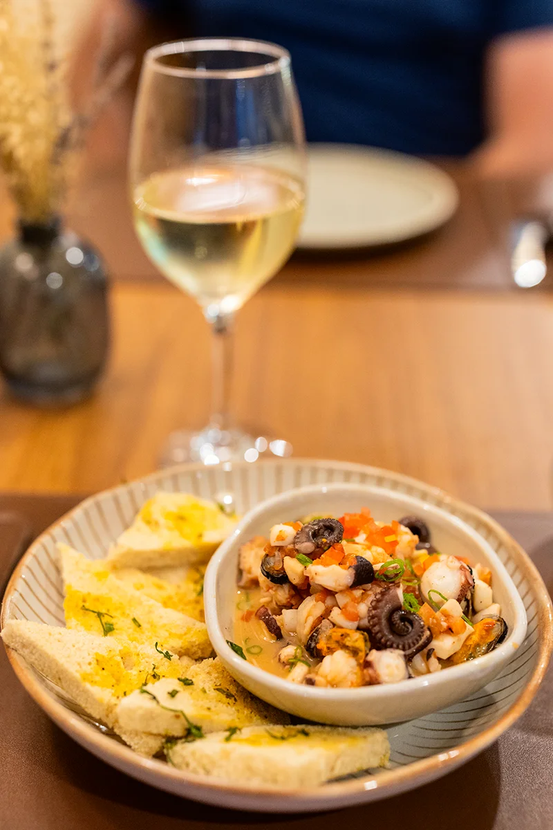 Seafood dish with bread and wine