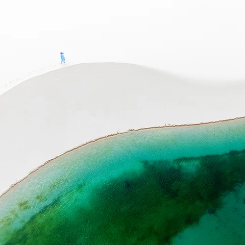 Aerial view of white sand dune and turquoise lagoon in Lençóis Maranhenses