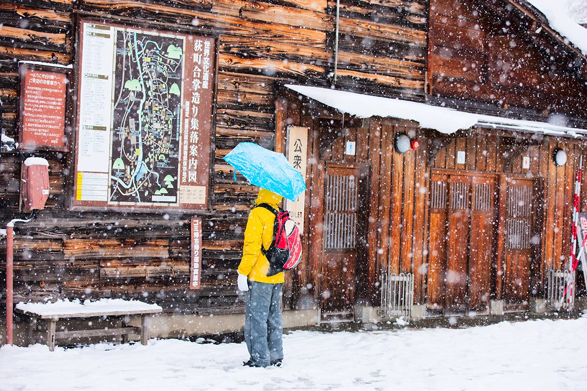 Tourist with umbrella in snowy Shirakawa-go village