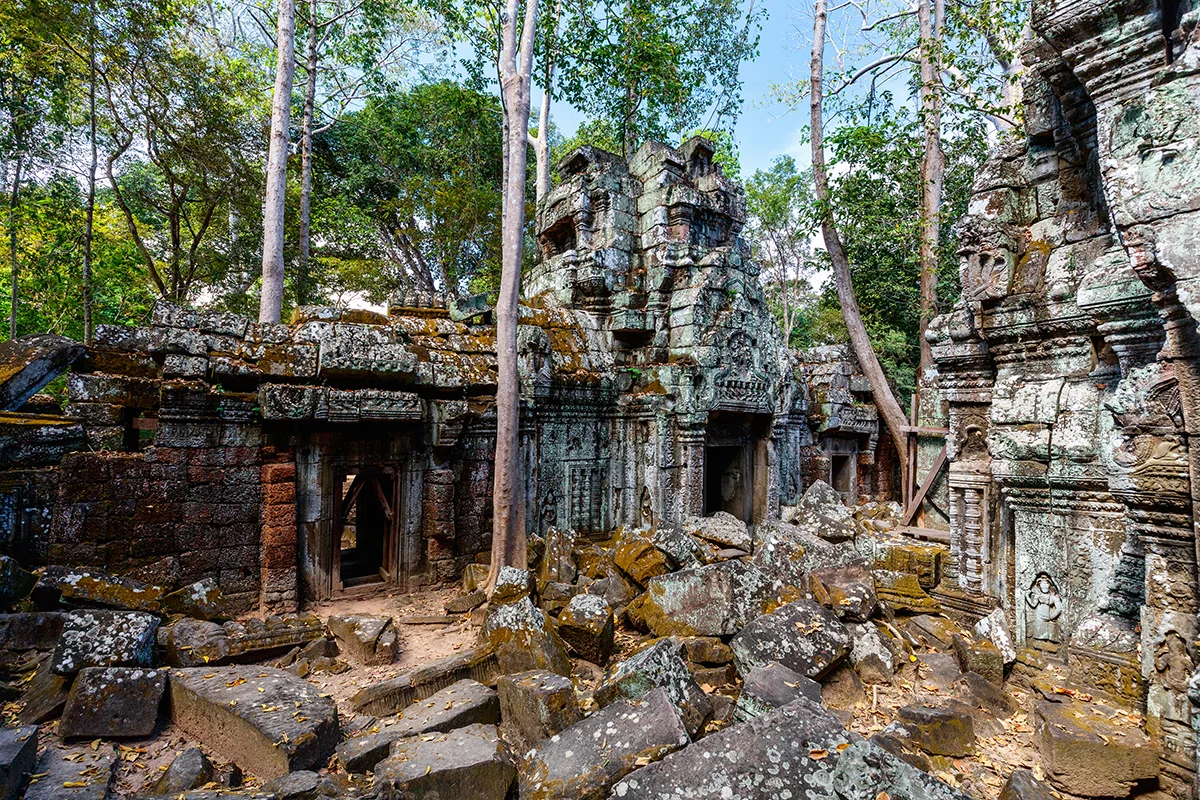 Mostly unrestored Ta Nei temple in Angkor showing ancient stone structures partially reclaimed by jungle