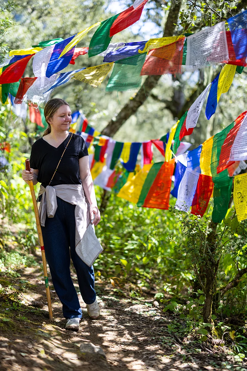 Person walking among colorful prayer flags