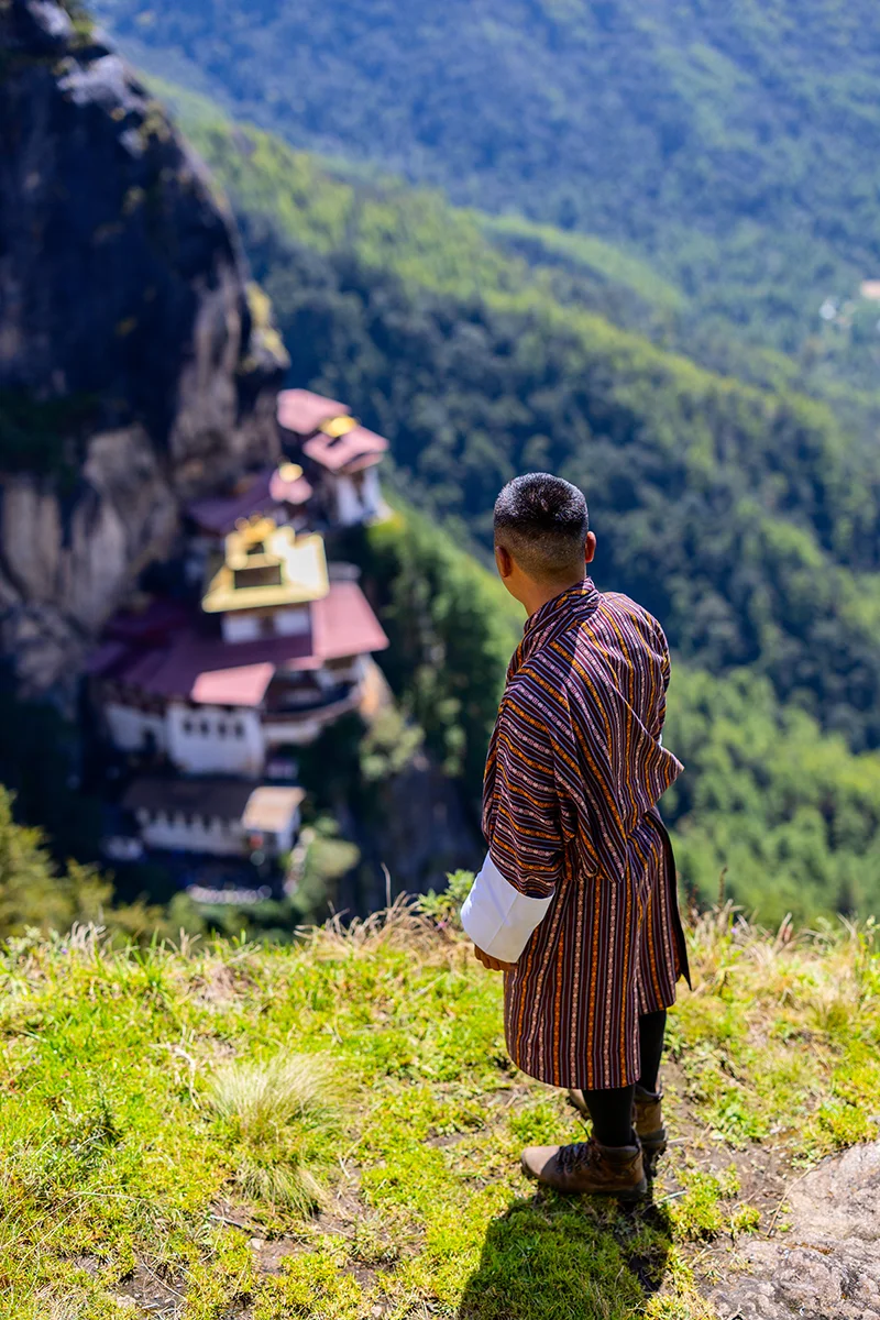 Bhutanese man overlooking cliffside Tiger's Nest monastery view
